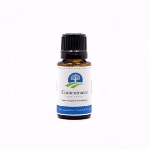May include: A small amber glass bottle with a black cap. The label reads "Contentment" with a tree logo and the words "A state of happiness and satisfaction." The bottle contains 15 ml (0.51 fl oz) of 100% essential oil.