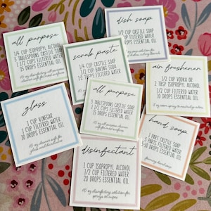 May include: Nine white labels with black text, each with a different cleaning solution recipe. The labels are for all-purpose cleaner, glass cleaner, dish soap, scrub paste, air freshener, hand soap, and disinfectant. The recipes include ingredients like Castile soap, isopropyl alcohol, filtered water, and essential oils.