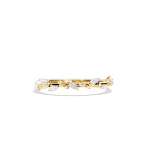 May include: A delicate gold ring featuring a leaf and vine design. The ring is adorned with marquise-cut and round-cut white gemstones, creating a nature-inspired aesthetic. The ring is set against a white background.