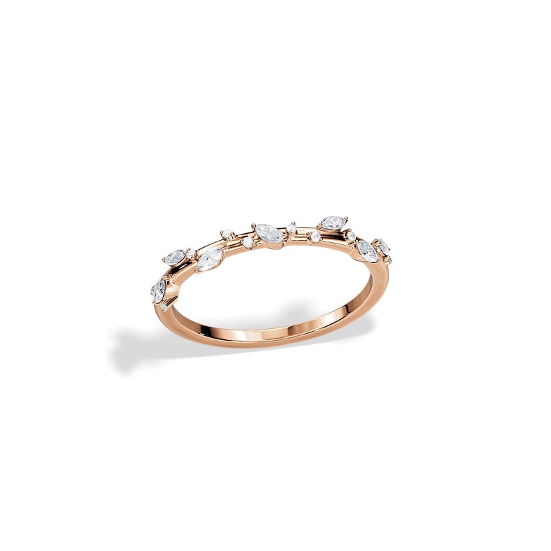May include: Rose gold ring featuring a delicate design of marquise and round-cut diamonds. The ring's band is a smooth, polished rose gold, with the diamonds arranged in a subtle, organic pattern across the top.