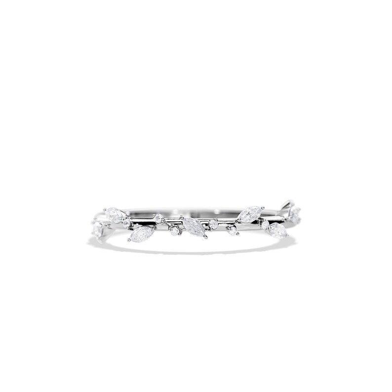 May include: A delicate silver ring featuring a leaf design. The ring is adorned with multiple clear, marquise-cut gemstones and smaller round stones, creating a nature-inspired aesthetic. The ring is set against a white background.