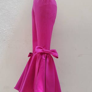 Peut inclure: Pantalon rose fuchsia &agrave; jambe large avec un grand n&oelig;ud au bas de la jambe.