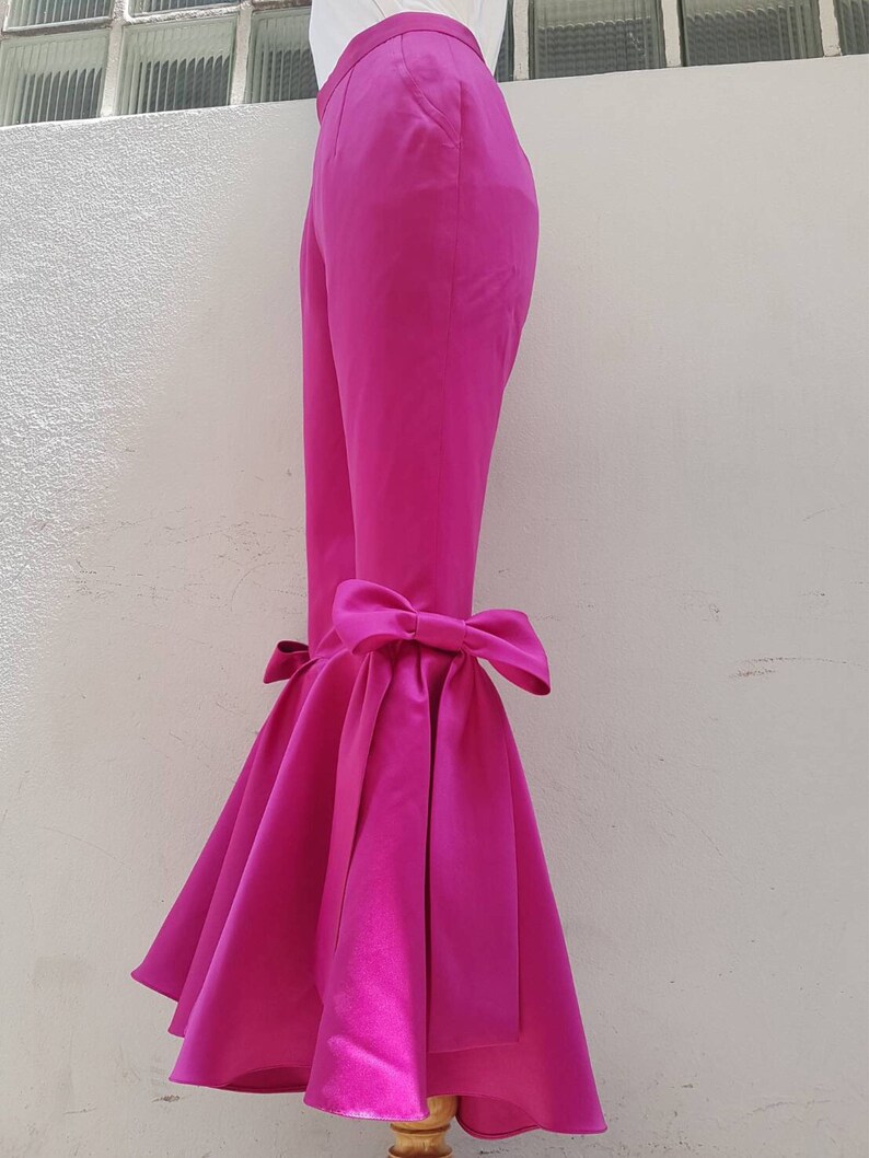 Peut inclure: Pantalon rose fuchsia &agrave; jambe large avec un grand n&oelig;ud au bas de la jambe.