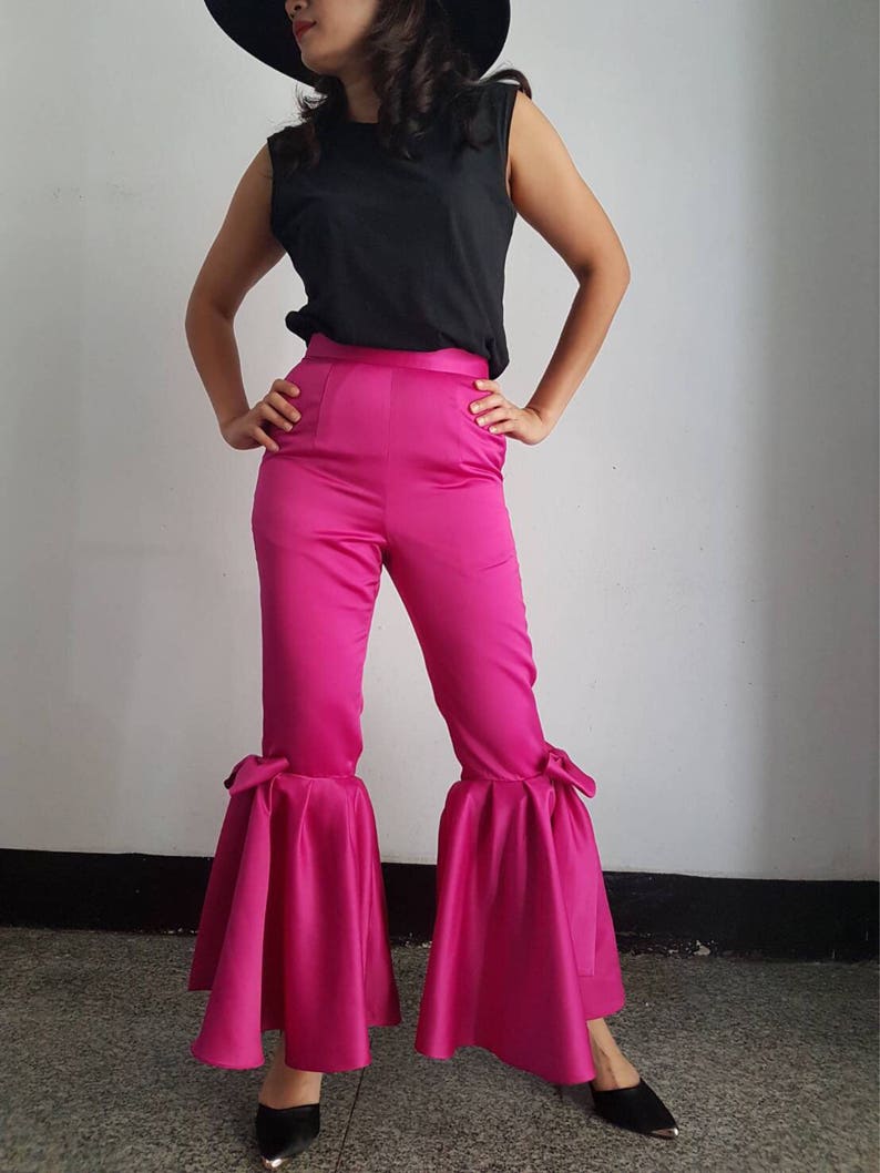 Peut inclure: Un pantalon large rose vif &agrave; taille haute et ourlet &agrave; volants. Le pantalon a un d&eacute;tail de n&oelig;ud sur chaque c&ocirc;t&eacute; de l'ourlet.