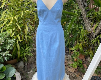 May include: A light blue maxi dress with a V-neckline and a white feather trim at the hem.
