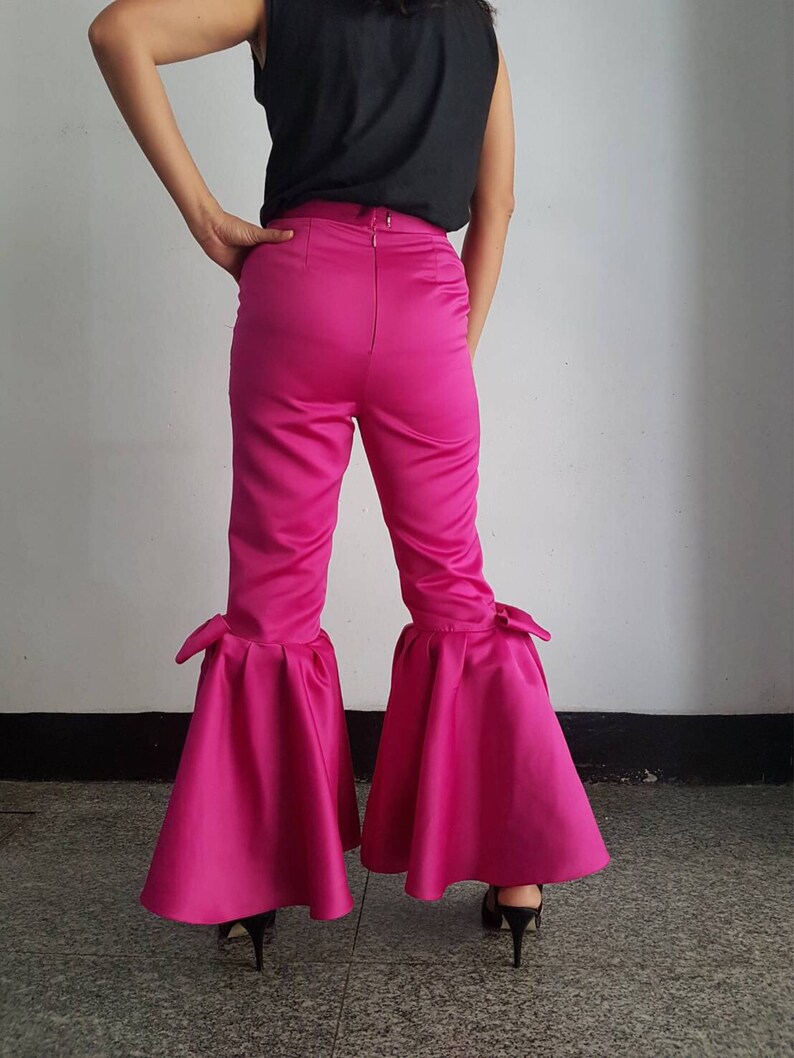 Peut inclure: Pantalon en satin rose avec une jambe large et un grand n&oelig;ud en bas de chaque jambe.