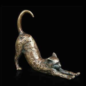 May include: A bronze sculpture of a cat stretching. The cat is in a yoga-like pose with its back arched and its tail curled over its head. The sculpture is detailed with textured fur and realistic features.