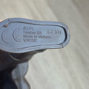 May include: Close-up of the bottom of a toy, showing the CE mark, copyright information, and the text "LFL Hasbro SA Made in Vietnam V3625C 13201".