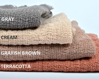 May include: Four fabric swatches stacked on top of each other. The swatches are in the colors gray, cream, grayish brown, and terracotta.