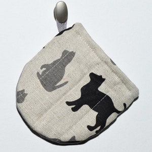 May include: A beige fabric pot holder with a black cat design. The pot holder has a silver hook.