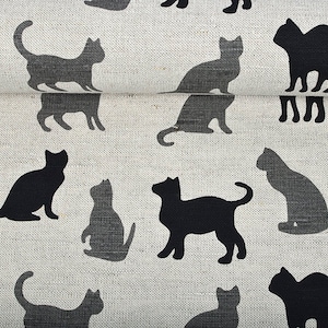 May include: A white fabric with a repeating pattern of black cat silhouettes. The cats are in various poses, including sitting, standing, and walking.