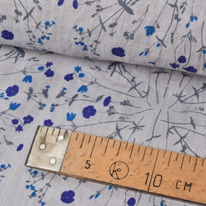 Puede incluir: Tela gris con un patr&oacute;n floral azul. Una regla de madera con el texto "10 cm" est&aacute; encima de la tela.