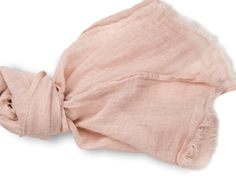 May include: A soft, pale pink linen scarf with a frayed edge. The scarf is folded and tied in a knot.