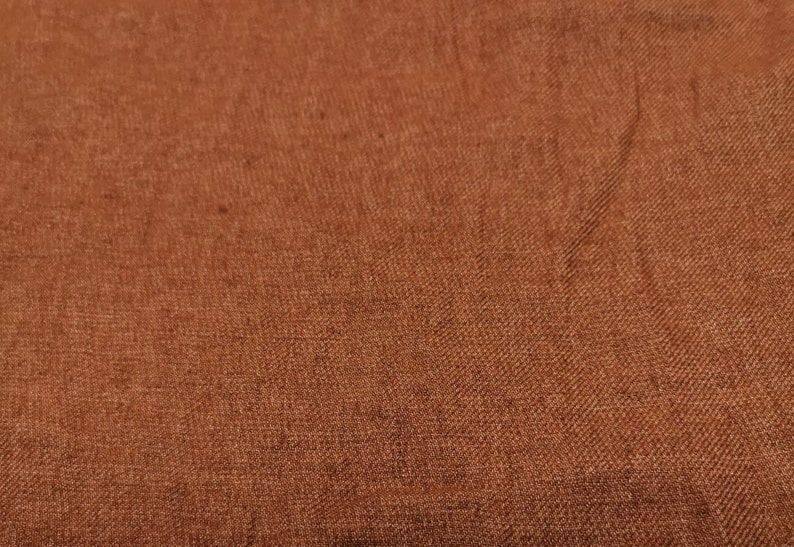 Puede incluir: Primer plano de una tela marr&oacute;n con un patr&oacute;n tejido texturizado.