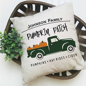 May include: A white pillow with the text "JOHNSON FAMILY PUMPKIN PATCH" and a green truck carrying pumpkins. The text below the truck reads "PUMPKINS HAY RIDES CIDER".