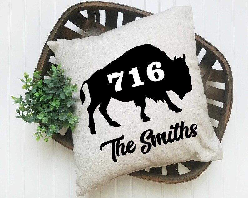 May include: A white pillow with a black silhouette of a buffalo with the number 716 printed on it. The text "The Smiths" is printed below the buffalo.