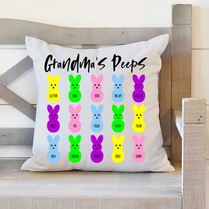 May include: White cushion with the text "Grandma's Peeps" printed in black. The cushion features a grid of 18 colourful marshmallow bunny images, each with a name printed below.