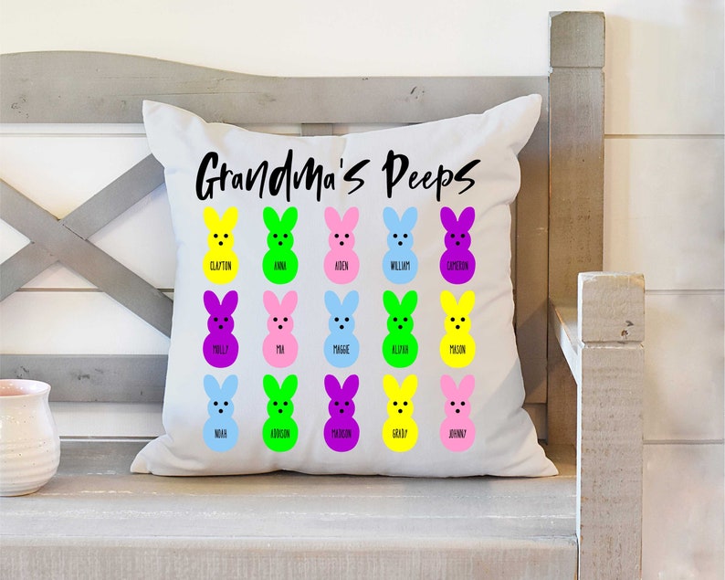 May include: White cushion with the text "Grandma's Peeps" printed in black. The cushion features a grid of 18 colourful marshmallow bunny images, each with a name printed below.