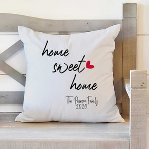 May include: White throw pillow with black text that reads "home sweet home" with a red heart. The text "The Pearson Family 2020" is also printed on the pillow.