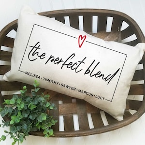 May include: A white pillow with black text that reads "the perfect blend" with a red heart above the text. The text also includes the names Melissa, Timothy, Sawyer, Marcus, and Lucy.