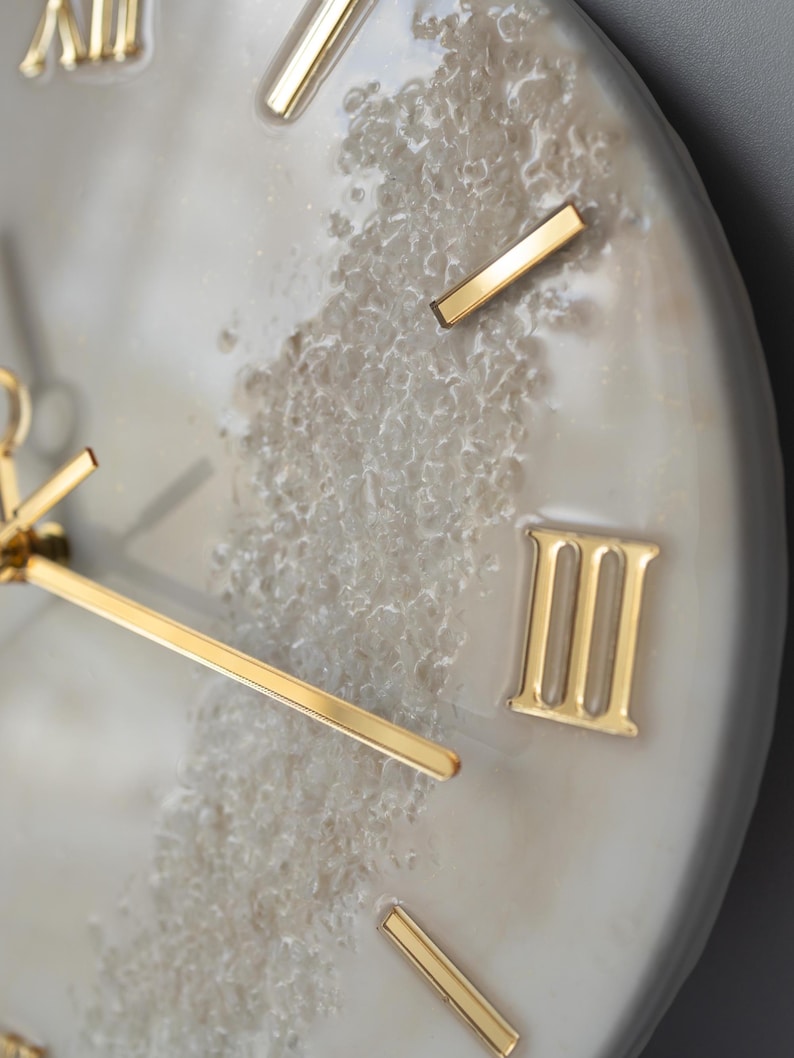Close-up of the clock's hands and Roman numeral markers, with a focus on the luxurious finish.