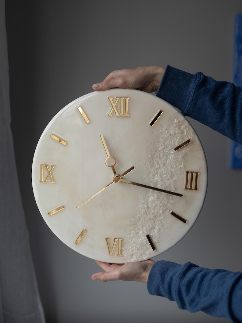 A person holding the handcrafted marble resin clock, showcasing its delicate details and size.