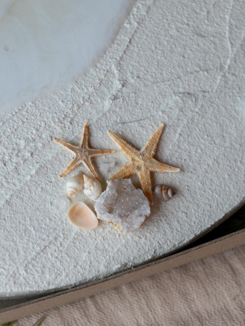 Elegant nautical-themed wall clock with acrylic hands and a beach-inspired aesthetic.