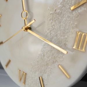 Angle shot of the wall clock with a blurred background, showing the fine details of the resin design.