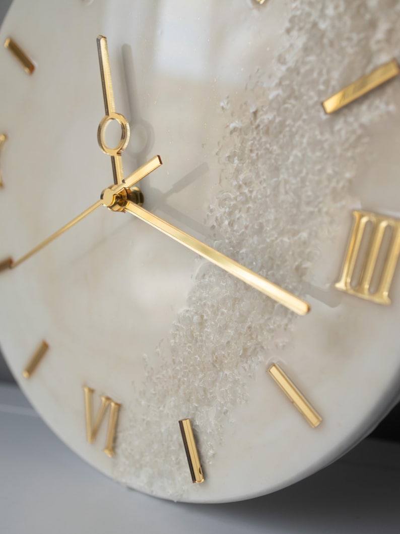 Angle shot of the wall clock with a blurred background, showing the fine details of the resin design.