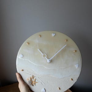 30 cm beige resin clock with ocean waves and natural shells for modern interiors.