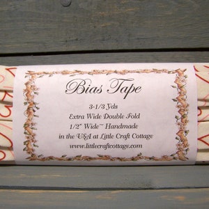 May include: A package of 3-1/3 yards of extra wide double fold bias tape, 1/2 inch wide, handmade in the USA at Little Craft Cottage. The tape is white with a pink and red heart pattern.