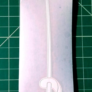 Pu&ograve; includere: Adesivo in vinile bianco di una lettera D stilizzata con una lunga linea sottile che si estende dalla parte superiore.