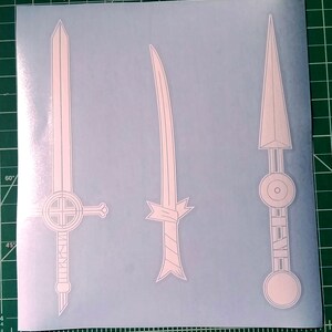 Pu&ograve; includere: Tre disegni di spade di contorno bianco su uno sfondo blu. Le spade sono di stili diversi, una con una guardia incrociata, una con un nastro legato attorno al manico e una con una guardia circolare.