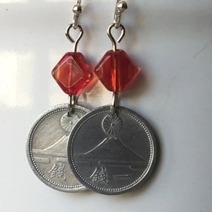 May include: Silver earrings with red glass beads and Japanese coins featuring Mount Fuji. The coins have the Japanese characters "&yen;" and "銭" on them.