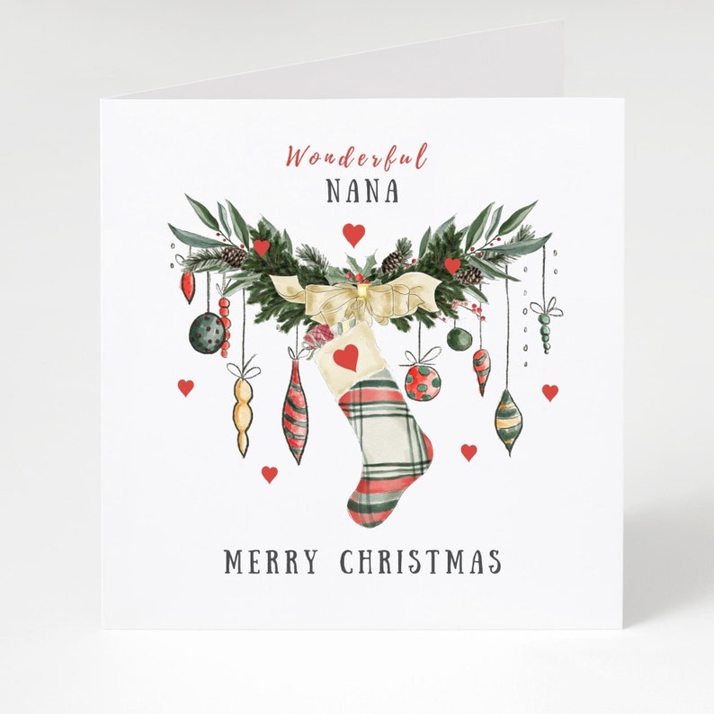 Op de afbeelding: Een kerstkaart met een aquarelontwerp. De kaart toont een slinger met ornamenten, een geruite kous en de tekst "Wonderful NANA" en "MERRY CHRISTMAS" in rood en zwart.