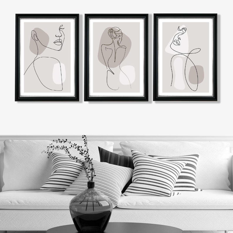 May include: Set of three black framed prints with minimalist line drawings of female figures on a light grey background. Each print features a different pose and abstract shapes.