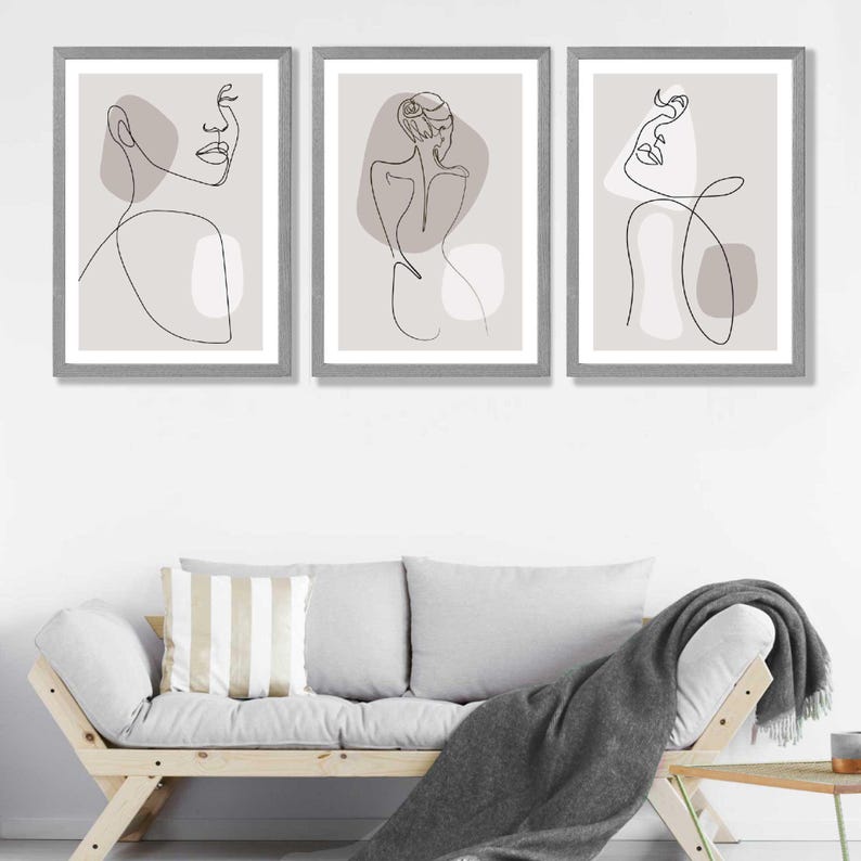 May include: Three framed prints featuring minimalist line drawings of figures against a light grey background. The figures are drawn in black lines and have abstract shapes in shades of grey.