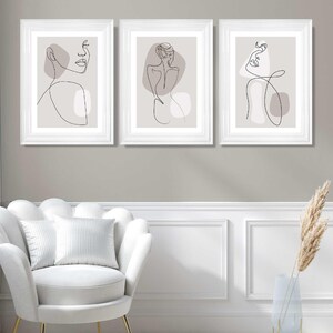 May include: Three framed prints featuring minimalist line drawings of figures in a neutral colour palette. The figures are depicted in various poses, with a focus on the lines and shapes of the body.