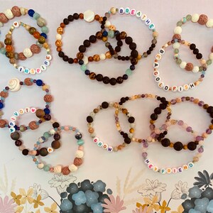 Pu&ograve; includere: Una collezione di braccialetti di perline in vari colori e trame. Alcuni braccialetti presentano perline con lettere che compongono parole come "inspire", "breathe", "be a goldfish", "pivot", "grow" e "hey friend". I braccialetti sono realizzati con una variet&agrave; di perline.