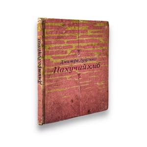 May include: A vintage book with a red cover and gold lettering. The title is "Пахучий хліб" by Дмитро Луценко.