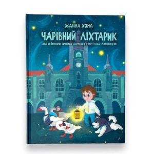 May include: A blue book cover with a title in Ukrainian that reads "CHARIVNY LIHTARYK" or "Magic Lantern". The cover features a boy with a lantern, a dog, and geese walking in front of a building at night.