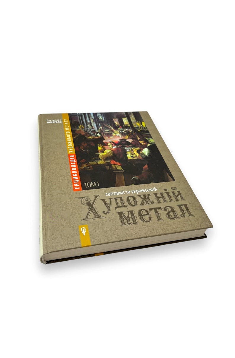 May include: A brown book with the title "Світовий та український Художній Метал" (World and Ukrainian Artistic Metal) and the text "Енциклопедія художнього металу" (Encyclopedia of Artistic Metal) on the spine. The book is closed and the cover features a painting of people in a workshop.