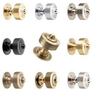 May include: Nine door knobs in a range of metallic finishes, such as gold, silver, black, and bronze. Each knob has a circular design with concentric ridges and a rounded centre, suitable for home decor.