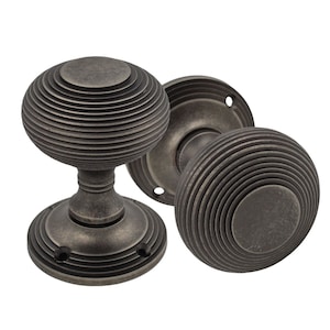 May include: A set of antique door knobs in a dark grey finish. The knobs feature a ribbed, spherical design, with a matching backplate. These vintage-style door handles would be a stylish addition to any interior door, adding a touch of classic charm.