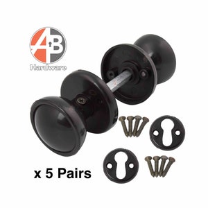 May include: Dark brown door knobs with matching keyhole covers and screws. The image shows five pairs of door knobs. The door knobs are oval-shaped and have a glossy finish. The hardware is set against a white background.