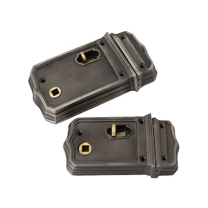 May include: Two dark grey metal door latches in an antique style. Each latch features a rectangular shape with decorative edges, a brass-coloured keyhole, and a handle. These latches are designed for a classic or vintage aesthetic.
