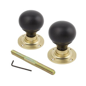 May include: A pair of black spherical door knobs with brass-coloured bases and fixings. The door knobs have a classic design and are suitable for interior doors. Includes a threaded rod and an Allen key.