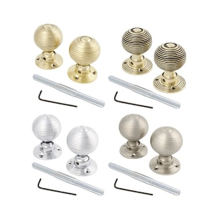 May include: Four sets of door knobs in gold, bronze, silver, and pewter finishes. Each set includes two spherical knobs with a ribbed design, a threaded rod, and an Allen key. The knobs are on a white background.