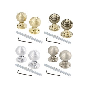 May include: Four pairs of decorative door knobs in gold, silver, and bronze finishes. Each knob has a ribbed, spherical design and is paired with a mounting plate, a long screw, and an Allen key. Ideal for home decor and hardware.