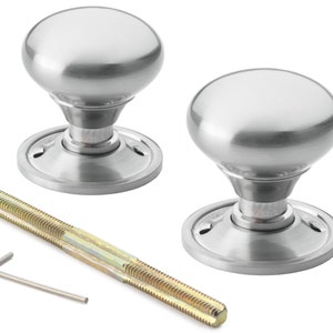 May include: Two brushed steel door knobs with a rounded shape. The knobs are shown with a threaded rod and an Allen key. The door knobs have a classic, simple design.